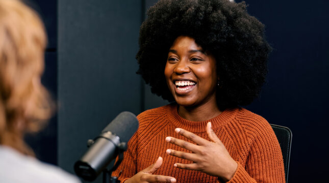 Smiling woman speaking into microphone in podcast studio