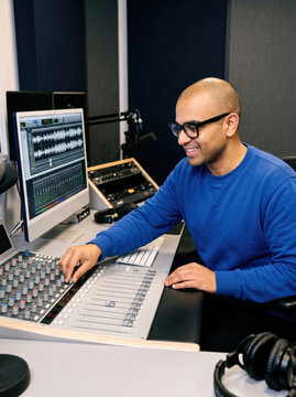 Sound engineer edit audio at recording studio console
