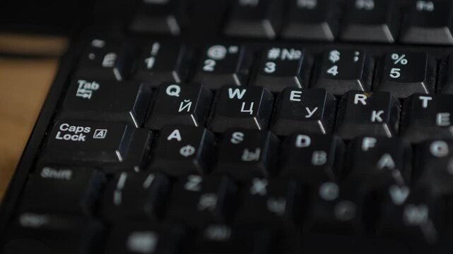 The upper-left section of a black computer keyboard. The frame shows the Tab and Caps Lock keys, function keys, and the top row of keys with dual labeling