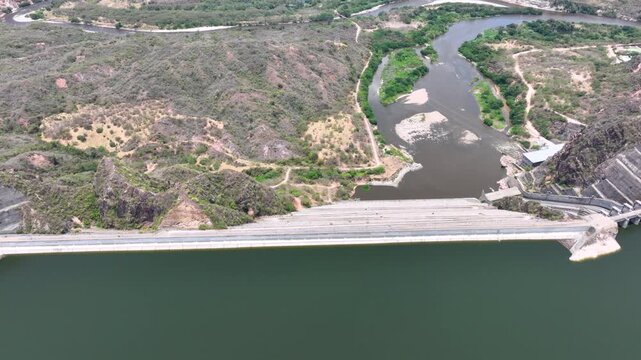 Large Hydroelectric Dam and Energy Infrastructure at El Quimbo Reservoir in Huila, Colombia. Establishing Shot. Aerial View.