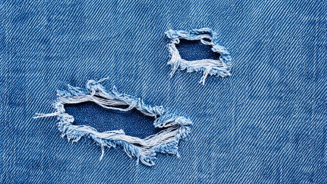 Zerrissener blauer Jeansstoff in detaillierter Makroaufnahme