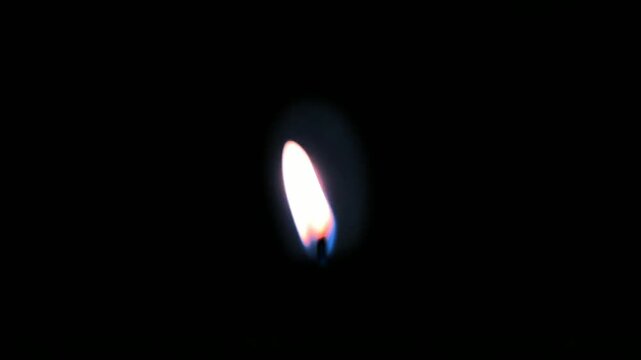 Burning candle flame flickering in the dark close up video