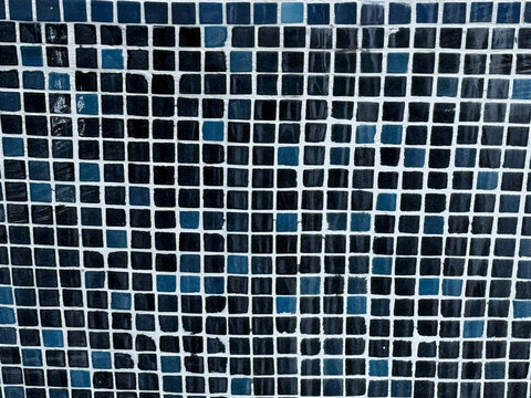 Blue and black square mosaic tiles with white grout lines forming