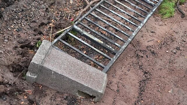 A metal grate laid on the ground, possibly used for repair or decoration