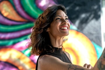 Joyful woman against colorful mural. © Rawpixel.com