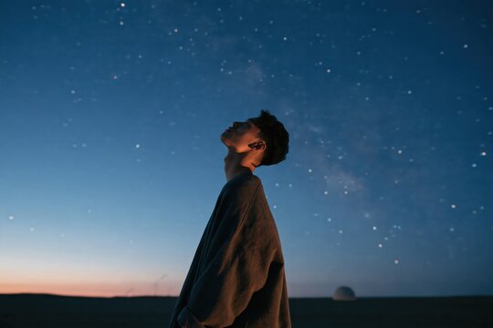 Stargazing person silhouette under starry sky at twilight for contemplative wallpaper background and nightscape poster design