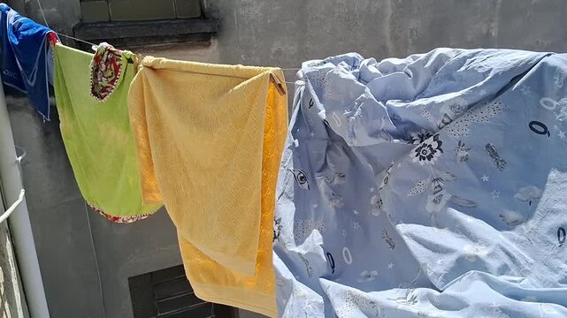 Colorful laundry hanging on outdoor clothesline drying in the bright sunlight