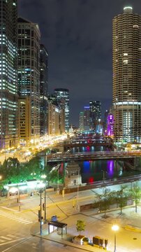 Beautiful time lapse of the many high-rise buildings along the Chicago River at night. Vertical video.