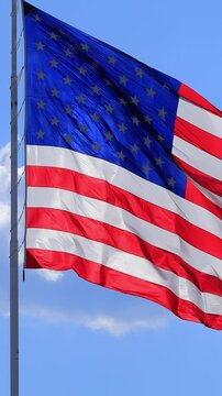 The flag of the United States of American blowing in the wind. Vertical video.