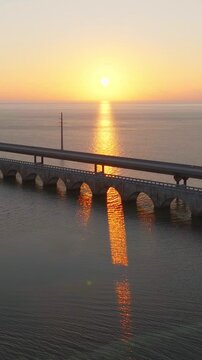 Aerial shot of the Seven Mile Bridge in Florida at sunrise. The bridge connects the Florida Keys on the way to Key West. Vertical video.