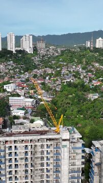 Aerial shot of the poor neighborhoods mixed in with new modern high-rises in Cebu City Philippines. Vertical Video.