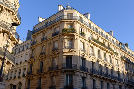 Corner facade of a Haussmann-style Parisian building with wrought-iron balconies and mansard roof near Orsay museum , 7th arrondissement, Paris, France