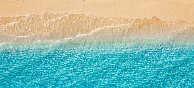 Aerial golden sandy beach ripples meeting turquoise crystal ocean waves abstract minimal top down summer coast. Peaceful nature seascape design scene. Artistic drone pattern paradise travel wanderlust