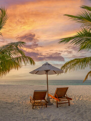 Fototapeta premium Tranquil sunset tropical beach sunbeds white umbrella coconut palm trees sandy shore sky ocean summer. Perfect couple vacation travel vertical scene. Relaxing holiday paradise leisure coastal escape