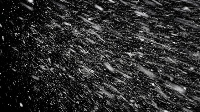 Blizzard snow streaks on black background. Heavy diagonal snowfall blowing in strong wind with motion blur, snowstorm overlay