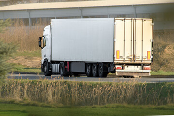 Modern white freight truck on open road © AlexGo
