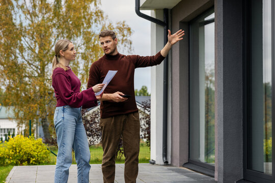 Real estate agent showing modern house to client. Realtor and customer inspecting property before buying