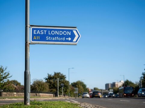 East London Stratford A11 Road Sign Directional Arrow with Cars and Blue Sky