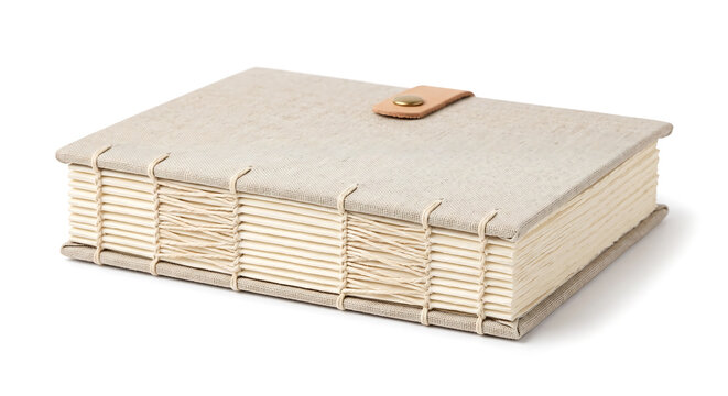 Hand-bound journal with a beige linen cover, featuring exposed coptic stitch binding and a tan leather strap closure with a metal button, isolated on a white background