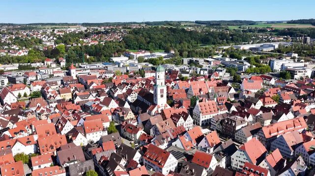 Malerische Panorama-Luftaufnahme von Biberach an der Ri&szlig; mit der historischen Altstadt, markanten Kircht&uuml;rmen und herbstlichen B&auml;umen unter blauem Himmel.