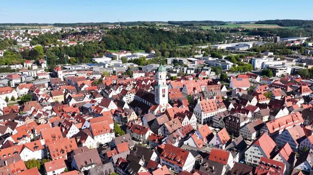 Malerische Panorama-Luftaufnahme von Biberach an der Ri&szlig; mit der historischen Altstadt, markanten Kircht&uuml;rmen und herbstlichen B&auml;umen unter blauem Himmel.
