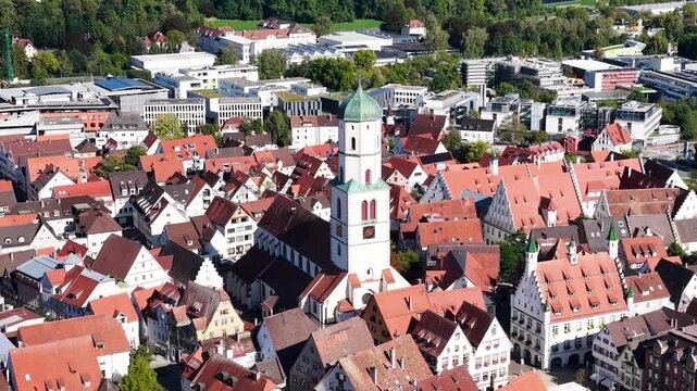 Malerische Panorama-Luftaufnahme von Biberach an der Ri&szlig; mit der historischen Altstadt, markanten Kircht&uuml;rmen und herbstlichen B&auml;umen unter blauem Himmel.