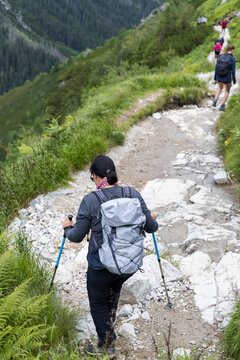 Woman hiking on stony mountain trail