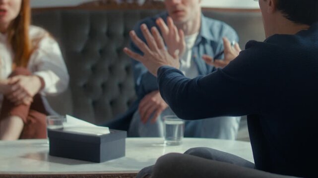 Psychologist calming down couple fighting during therapy session and providing professional advice on how to resolve their conflict. Close up view