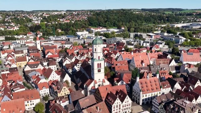 Malerische Panorama-Luftaufnahme von Biberach an der Ri&szlig; mit der historischen Altstadt, markanten Kircht&uuml;rmen und herbstlichen B&auml;umen unter blauem Himmel.
