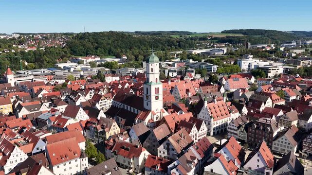Malerische Panorama-Luftaufnahme von Biberach an der Ri&szlig; mit der historischen Altstadt, markanten Kircht&uuml;rmen und herbstlichen B&auml;umen unter blauem Himmel.