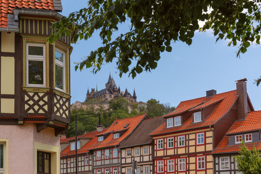 Traditional half-timbered houses with red tiled roofs and historic architecture on the hill in Wernigerode, Germany.