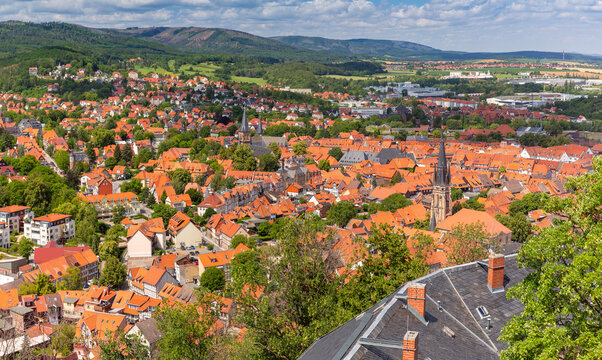 Panoramic view of Wernigerode with red tiled rooftops, historic architecture, church towers and the green Harz landscape in Germany.