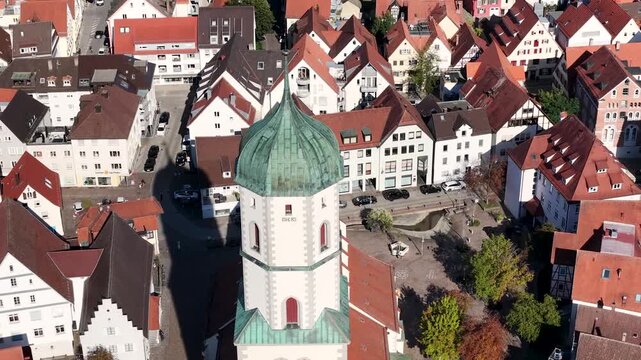 Malerische Panorama-Luftaufnahme von Biberach an der Ri&szlig; mit der historischen Altstadt, markanten Kircht&uuml;rmen und herbstlichen B&auml;umen unter blauem Himmel.