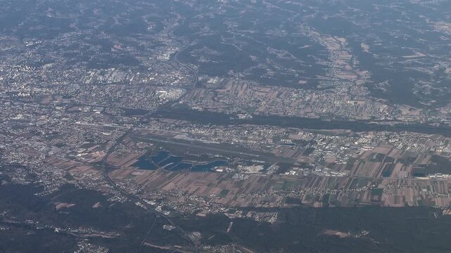flying from south to north along City of Graz in Austria with Graz Airport, downtown Graz and suburbs, as well as agricultural landscape around the city - 4k aerial video footage 