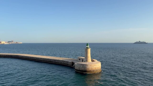 29 April 2026 Republic of Malta, Valletta Cruise Port, Saint Elmo lighthouse - cruise ship entering harbour passing famous sightseeing spot on sunny day