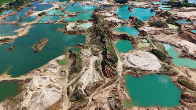 Top down abstract pattern of turquoise pits and white sand