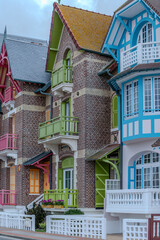 Fototapeta premium Houses of Mers-les-Bains, seaside town with 19th-century sea-bathing villas with colorful wooden balconies and white chalk cliffs, tourists destination in France