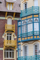 Fototapeta premium Houses of Mers-les-Bains, seaside town with 19th-century sea-bathing villas with colorful wooden balconies and white chalk cliffs, tourists destination in France