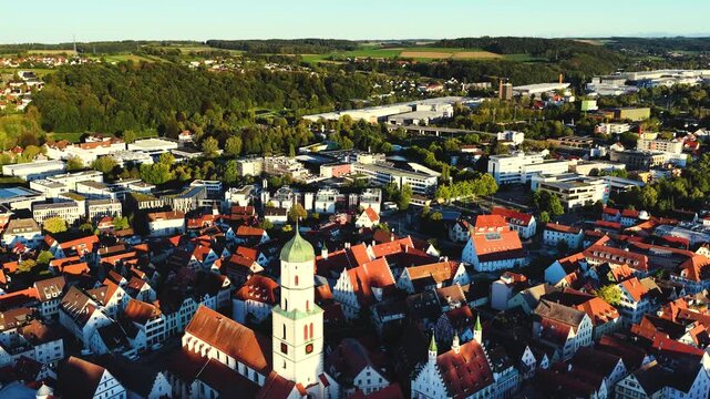 Malerische Panorama-Luftaufnahme von Biberach an der Ri&szlig; mit der historischen Altstadt, markanten Kircht&uuml;rmen und herbstlichen B&auml;umen unter blauem Himmel.