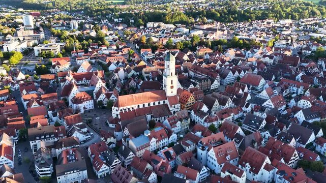 Malerische Panorama-Luftaufnahme von Biberach an der Ri&szlig; mit der historischen Altstadt, markanten Kircht&uuml;rmen und herbstlichen B&auml;umen unter blauem Himmel.