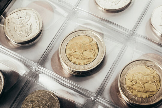 Isolated photo of south african rand coins collection in plastic holder album close up view.