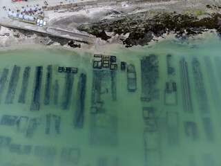 Aerial drone view of underwater oyster farms in Cancale, Brittany, covered during high tide, raditional sustainable aquaculture and production of premium French oysters, France © barmalini