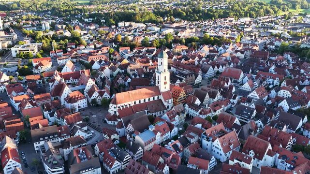 Malerische Panorama-Luftaufnahme von Biberach an der Ri&szlig; mit der historischen Altstadt, markanten Kircht&uuml;rmen und herbstlichen B&auml;umen unter blauem Himmel.