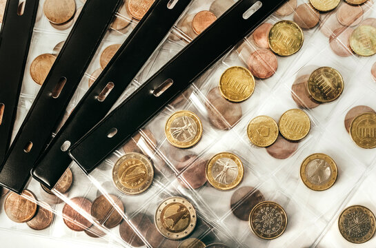 Isolated photo of euro coins collection in plastic holder album sheets on white background.