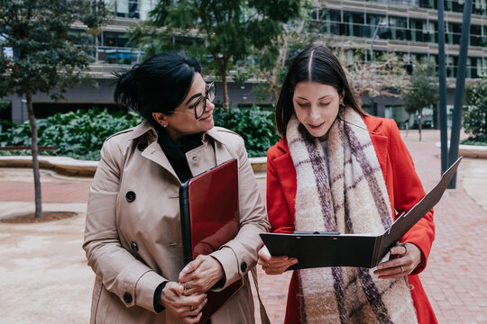 Young Hispanic women teamwork working in the business sector and using laptop outdoors in Public park in businesswoman empowerment concept in urban scene in winter