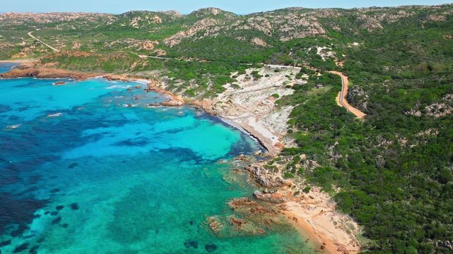 Aerial view of Bassa Trinita Beach in La Maddalena, Sardinia. Turquoise bay, sandy coastline and green Mediterranean hills create a beautiful island beach panorama.