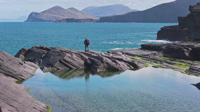 Person Beside a Reflective Tidal Pool on the Kerry Coast