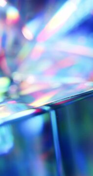 Light reflecting glass in brilliant saturated colors. Radiant lighting through a prism cube creating a visual of a colorful rainbow effect of light refraction. Spinning geometric abstract background.