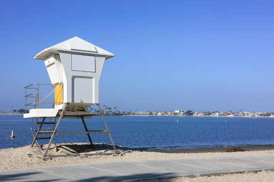 White lifeguard tower stands on the sandy beach of Mission Bay in San Diego under a clear blue sky, Southern California