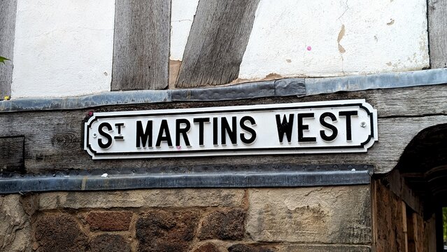 Vintage white St Martins West street sign on half-timbered Tudor building in historic UK town